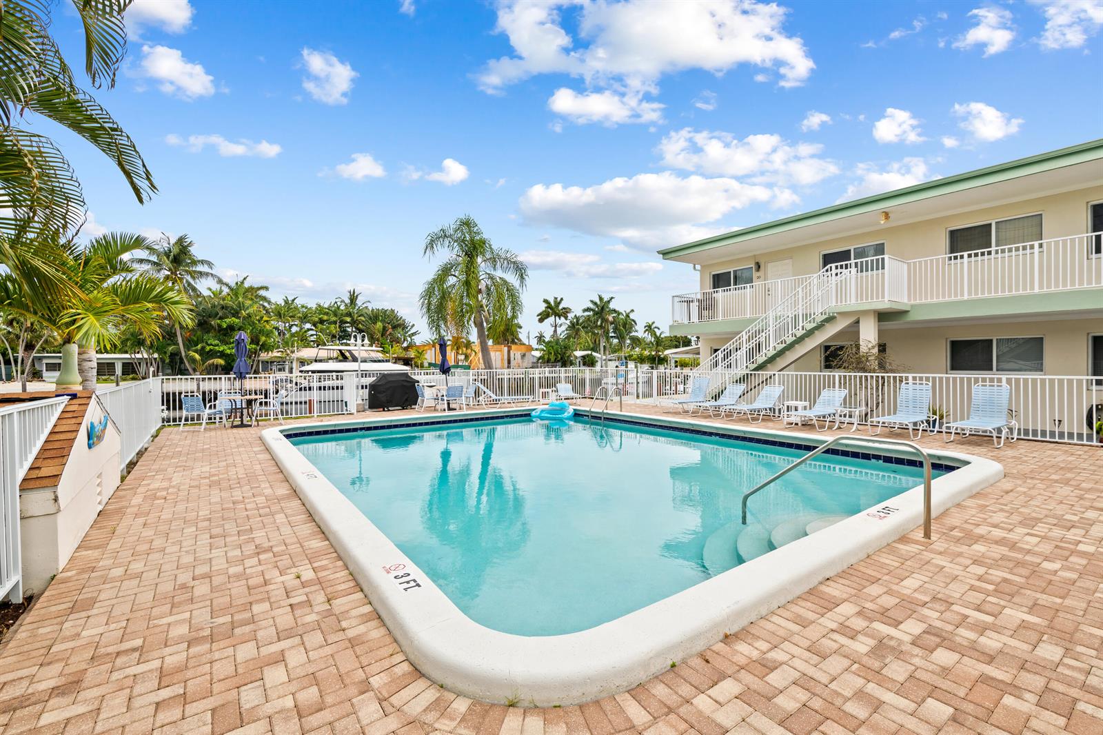 A rectangular swimming pool sits on a paved deck in front of a two-story building — 2601 NE 1st Street # 17, Pompano Beach FL 33062, POMPANO BEACH, FL