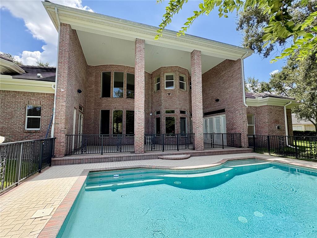 A two-story brick house features a covered patio overlooking a swimming pool — 2817 ROEHAMPTON CLOSE, TARPON SPRINGS, FL