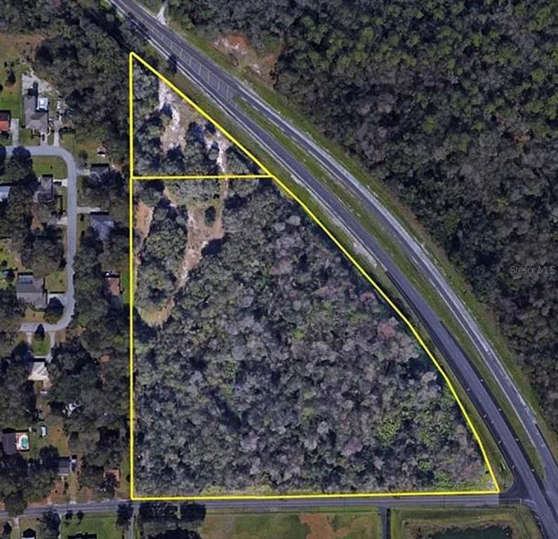 An aerial view shows two adjacent triangular parcels of land bordered by roads and trees — 9232 US HIGHWAY 98 N, LAKELAND, FL