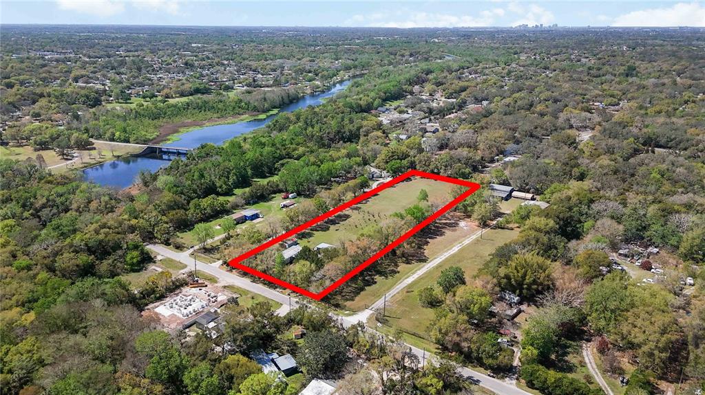 An aerial view shows a rectangular plot of land outlined in red near a river — 2700 AEIN ROAD, ORLANDO, FL