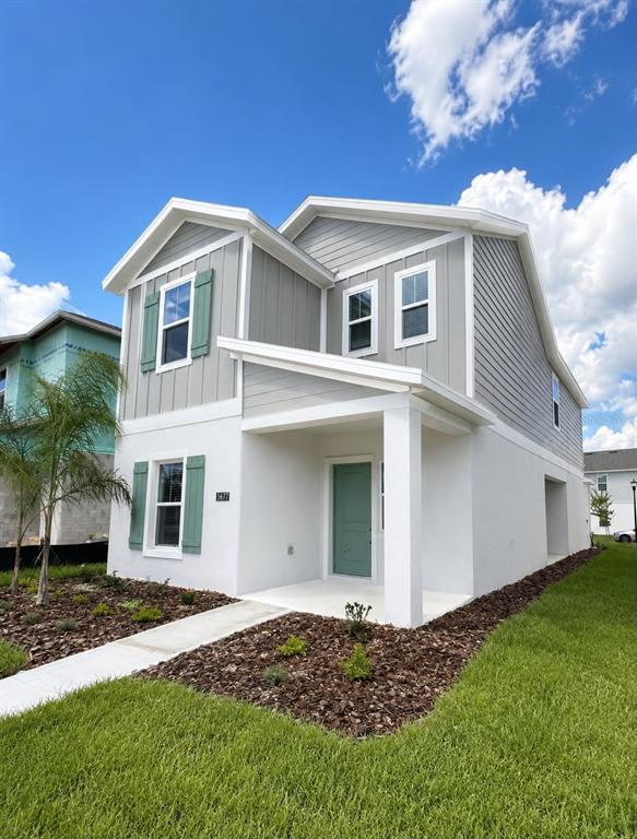 A two-story house with white stucco, gray siding, green shutters, and a covered front porch — 5677 LIVELINESS ALLEY, CLERMONT, FL