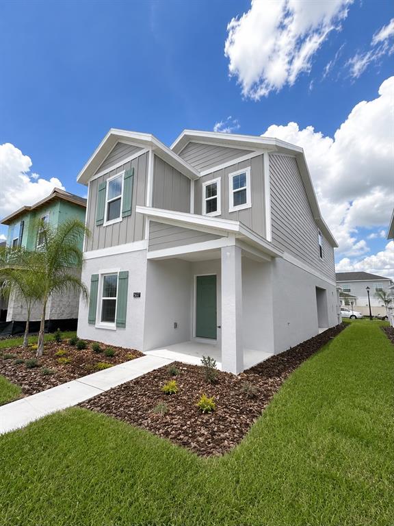A two-story house features gray siding, green shutters, and a covered front porch — 5677 LIVELINESS ALLEY, CLERMONT, FL