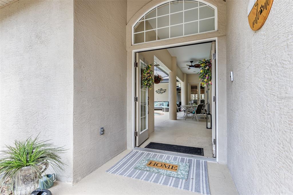 An open front door reveals a view through the home to a covered patio area — 3099 N BARTON CREEK CIRCLE, LECANTO, FL