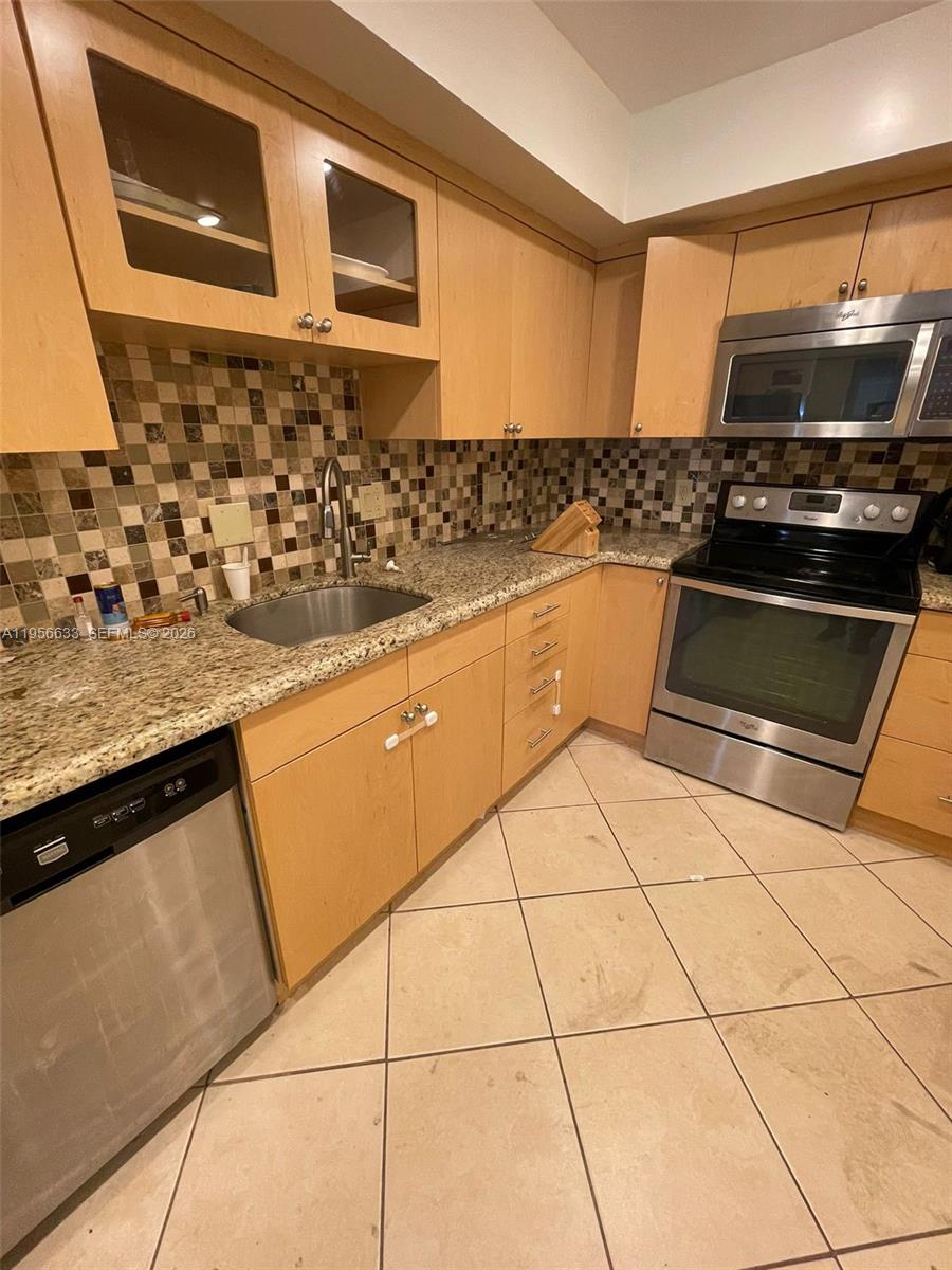 A kitchen features light wood cabinets, granite countertops, stainless steel appliances, and a tiled backsplash — 4000 N Hills Dr # 32, Hollywood FL 33021, HOLLYWOOD, FL