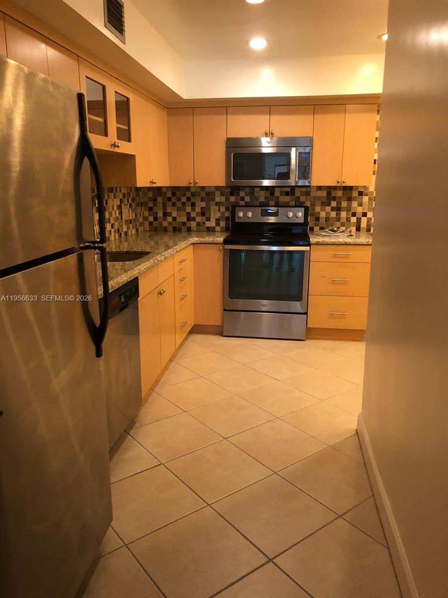 A kitchen features light wood cabinets, stainless steel appliances, granite countertops, and a tiled backsplash — 4000 N Hills Dr # 32, Hollywood FL 33021, HOLLYWOOD, FL