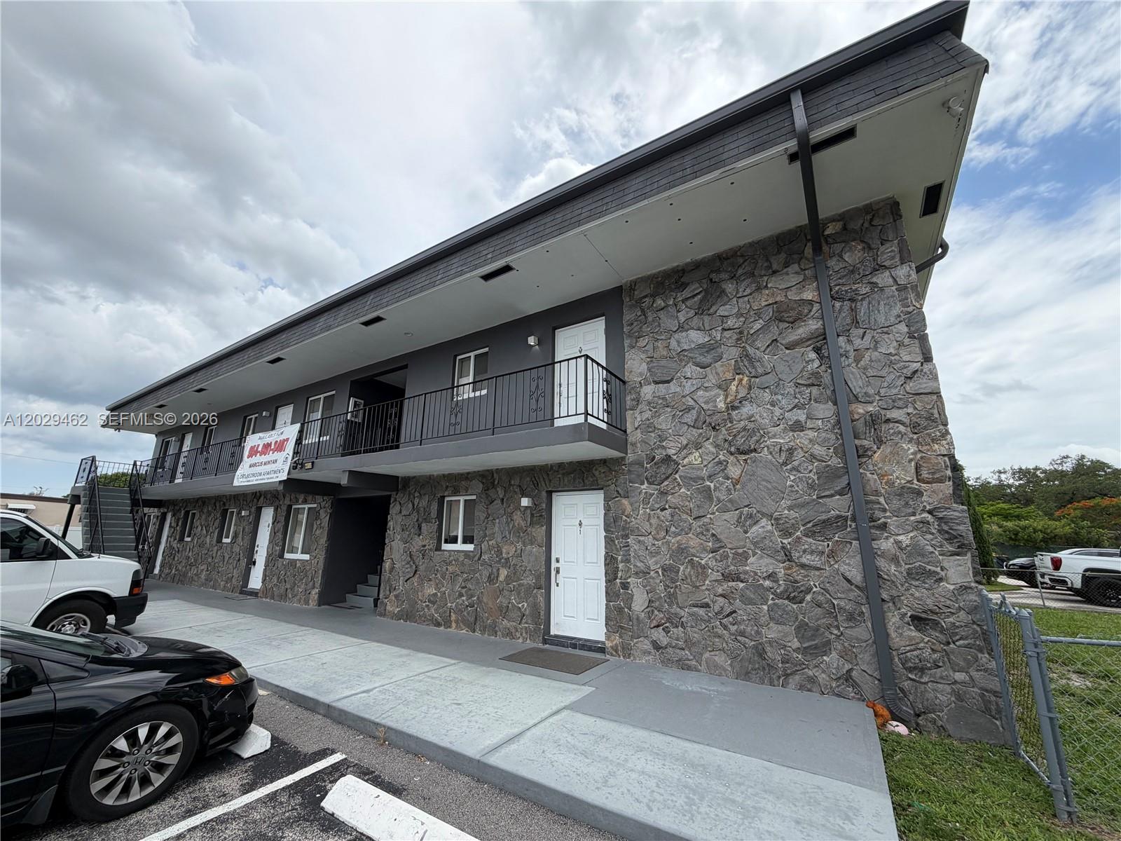 A two-story apartment building features a stone facade, gray exterior paint, and an upper balcony — 4850 SW 26th Ave # 4, Dania Beach FL 33312, DANIA BEACH, FL