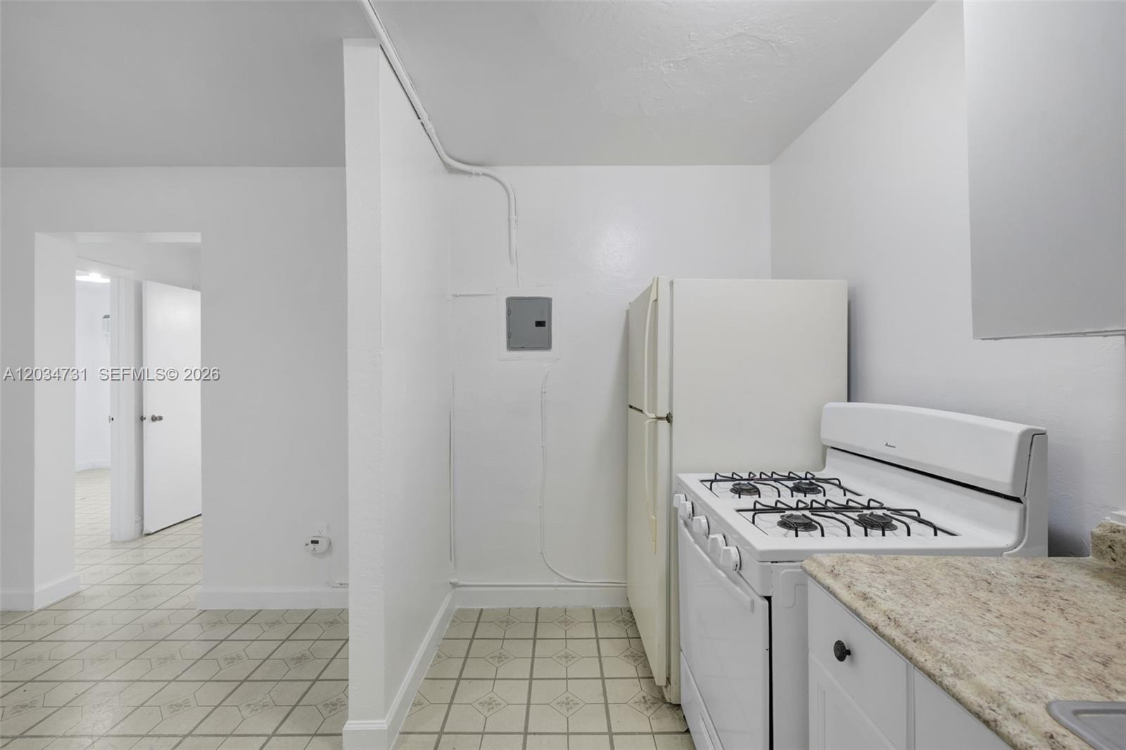 A kitchen features white appliances, a gas stove, and a wall-mounted electrical panel — 126 SW 18th Ave # 4, Miami FL 33135, MIAMI, FL
