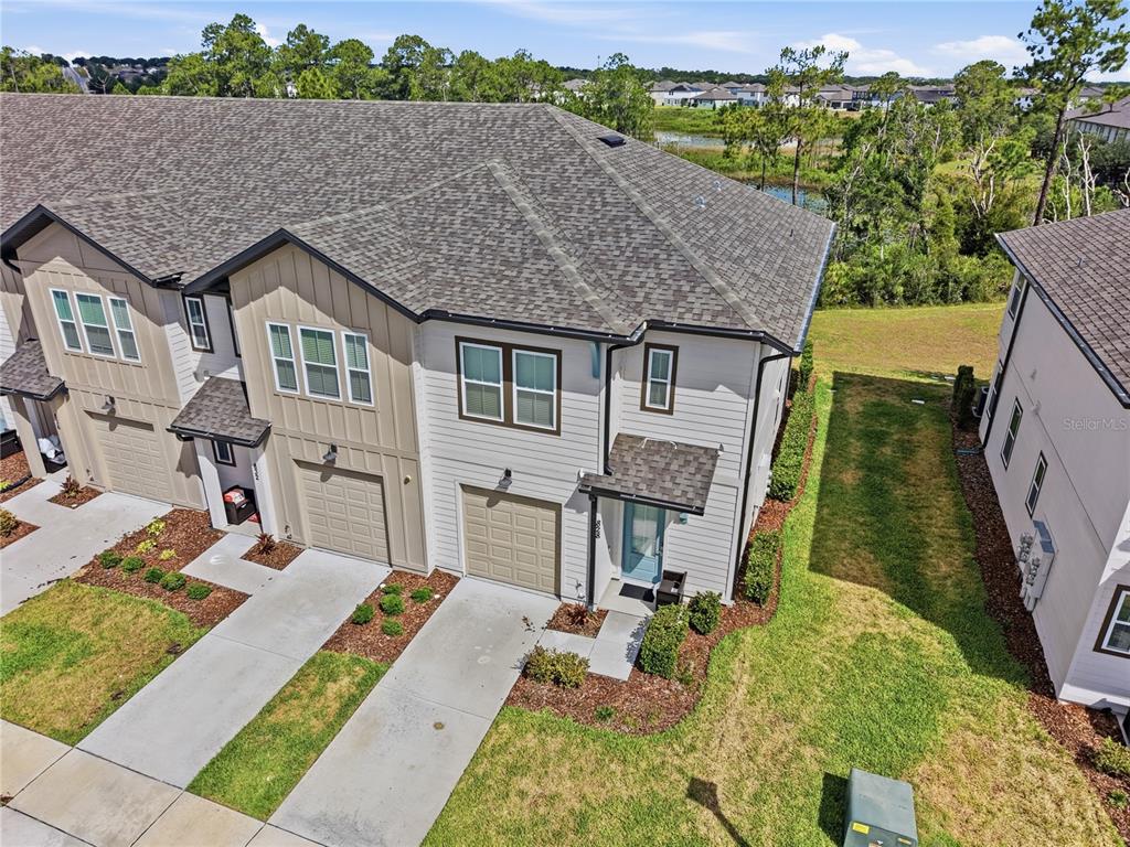 An aerial view shows the exterior of a two-story townhouse with a concrete driveway — 828 LONGBOAT DRIVE, DAVENPORT, FL