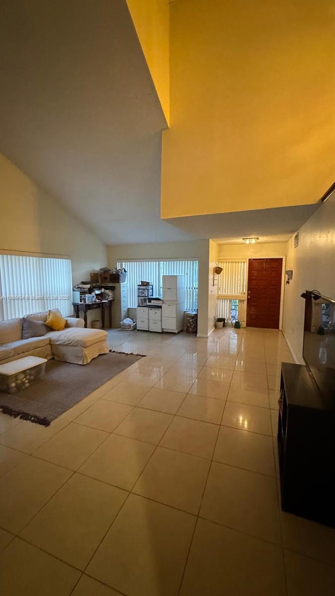 A spacious living room features high vaulted ceilings, light-colored tile flooring, and a sectional sofa — 15039 SW 89th Terr Rd, Miami FL 33196, MIAMI, FL