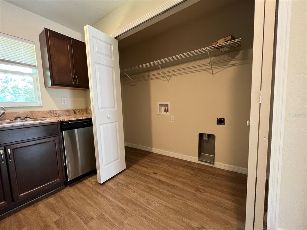 A kitchen area features dark wood cabinets, stainless steel appliances, and an adjacent laundry closet — 8526 JUNIPER ROAD UNIT 2, OCALA, FL