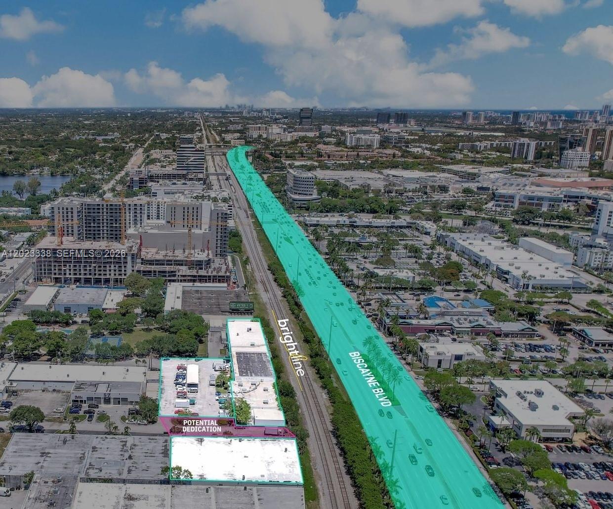 An aerial view shows a commercial property next to railroad tracks and Biscayne Boulevard — 2660 NE 189th St, Miami FL 33180, MIAMI, FL