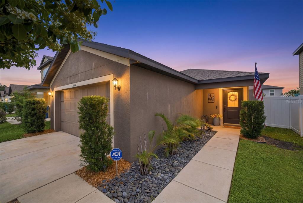 A single-story house with a tan stucco exterior and a two-car garage — 29196 FEDORA CIRCLE, BROOKSVILLE, FL