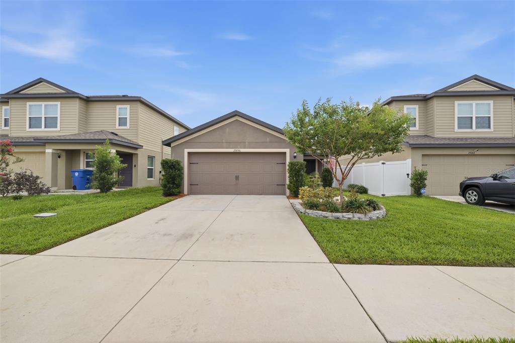 An exterior view of a single-story house situated between two two-story houses — 29196 FEDORA CIRCLE, BROOKSVILLE, FL
