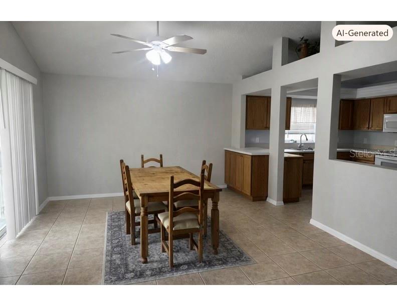 A dining area with a wooden table and chairs sits on a tiled floor — 27606 SKY LAKE CIRCLE, WESLEY CHAPEL, FL