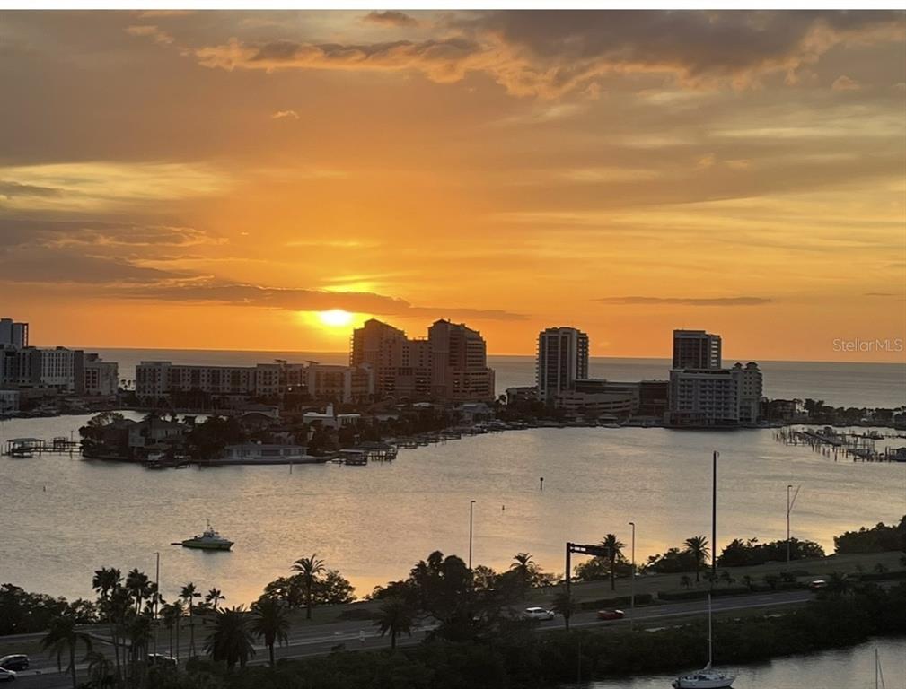 An elevated view of a sunset over a bay with high-rise buildings and boats — 31 ISLAND WAY UNIT 1403, CLEARWATER BEACH, FL