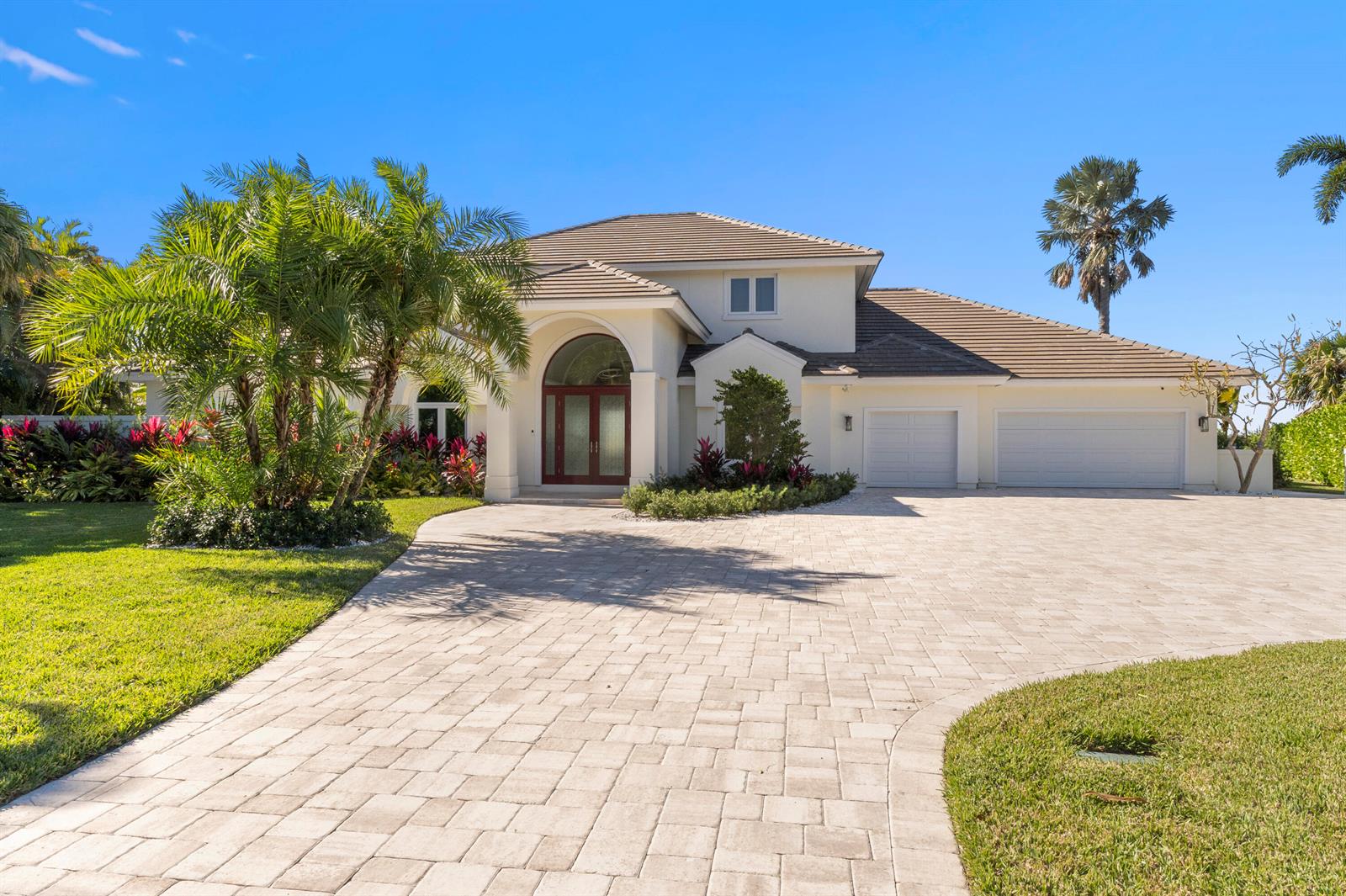 A two-story house with a paved driveway, palm trees, and a three-car garage — 526 Point Lane, Vero Beach FL 32963, VERO BEACH, FL