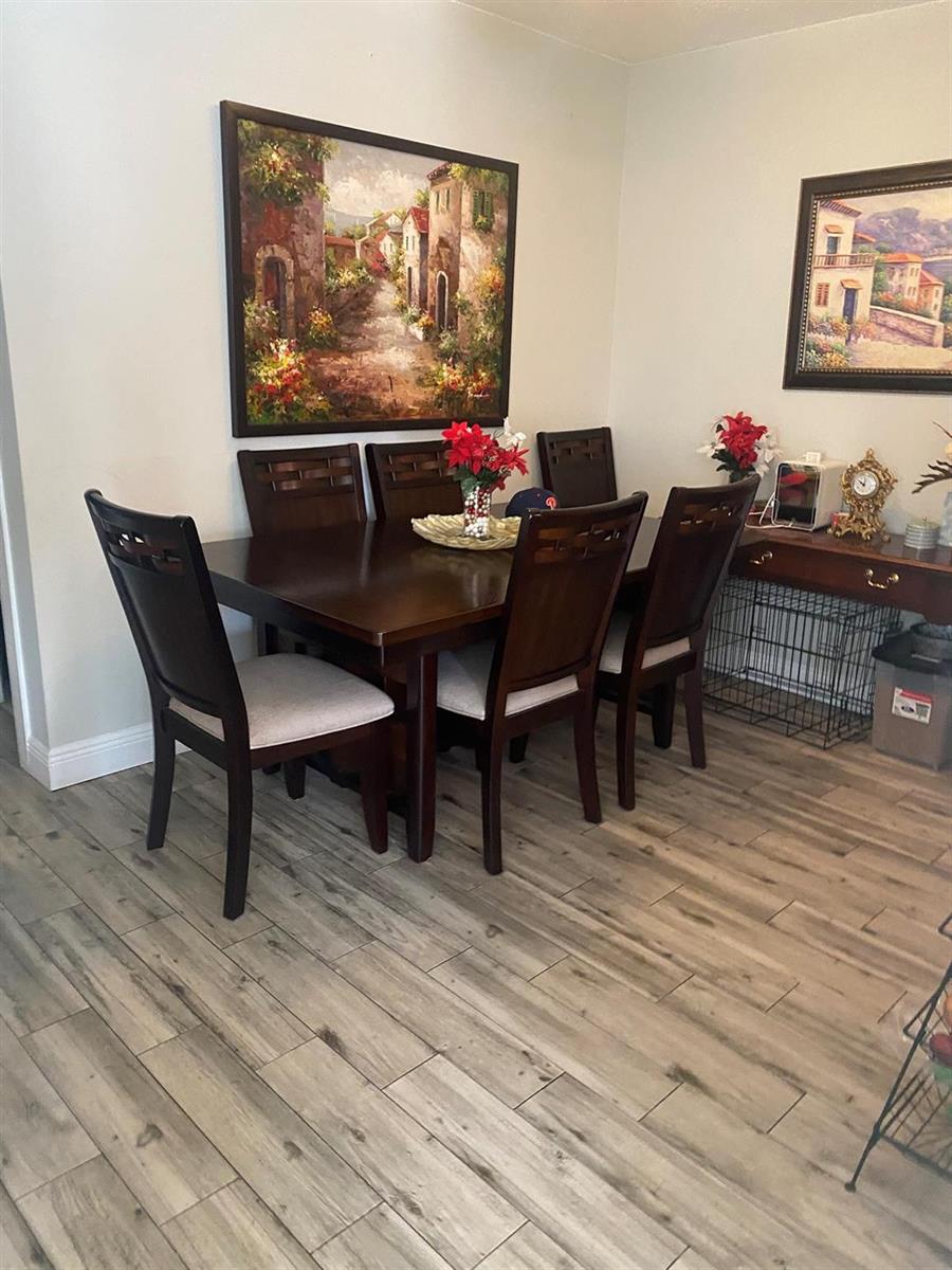 A dining room features a dark wood table, six chairs, and two framed landscape paintings — 225 SW 7th Street # 101, Boca Raton FL 33432, BOCA RATON, FL