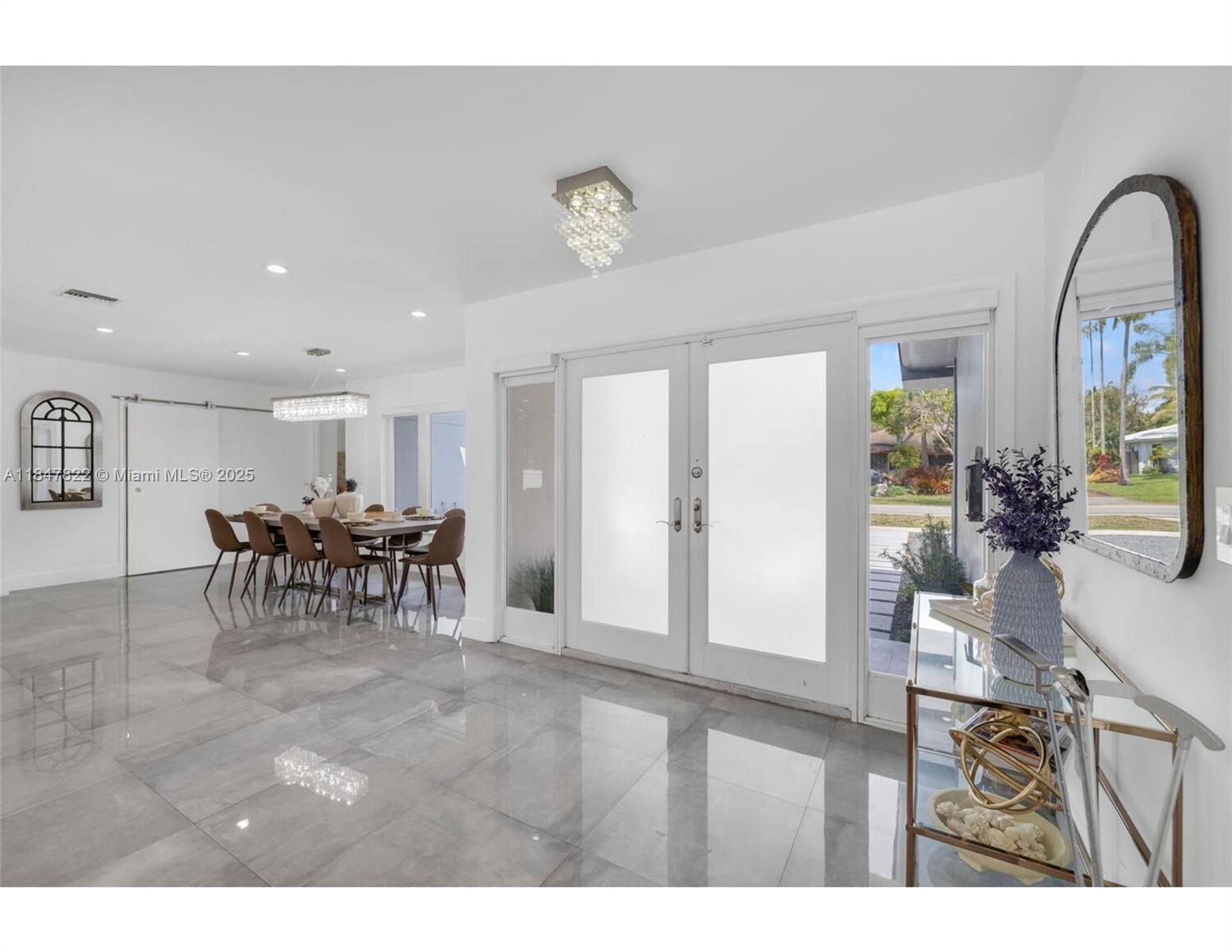 A bright entryway with glossy tile floors leads to a dining area and front door — 19810 NE 22nd av, Miami FL 33180, MIAMI, FL