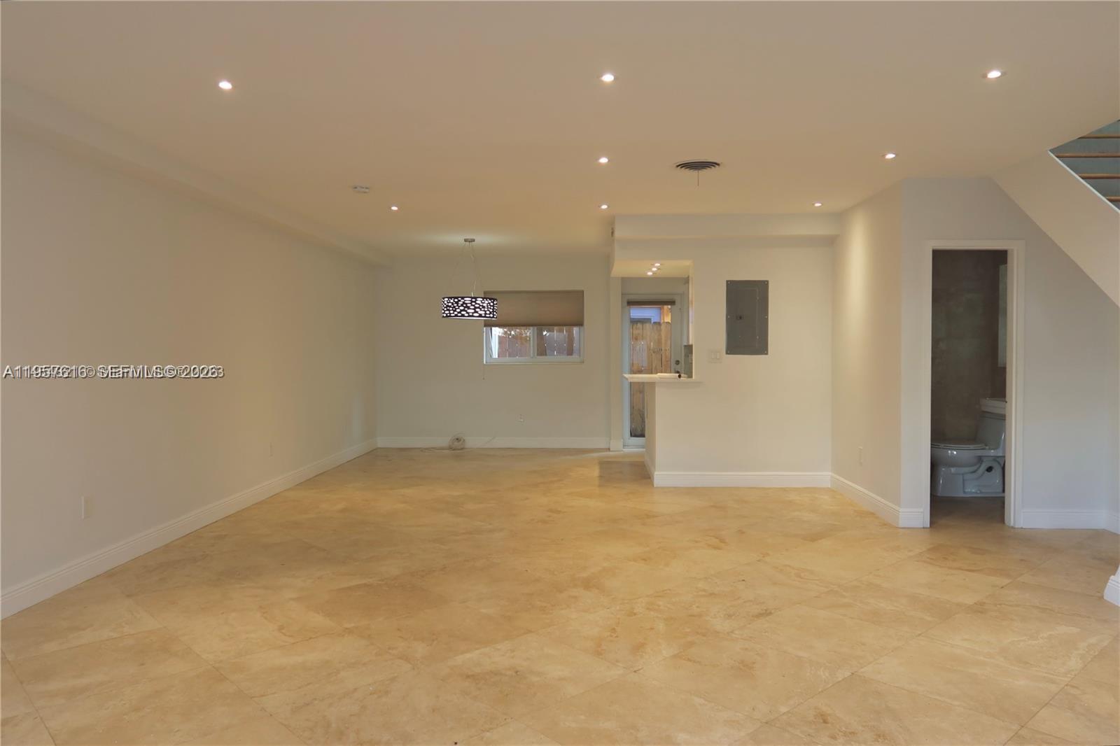 An open-concept living area features light-colored tile flooring, recessed lighting, and a small bathroom — 7312 Gary Ave # 7312, Miami Beach FL 33141, MIAMI BEACH, FL