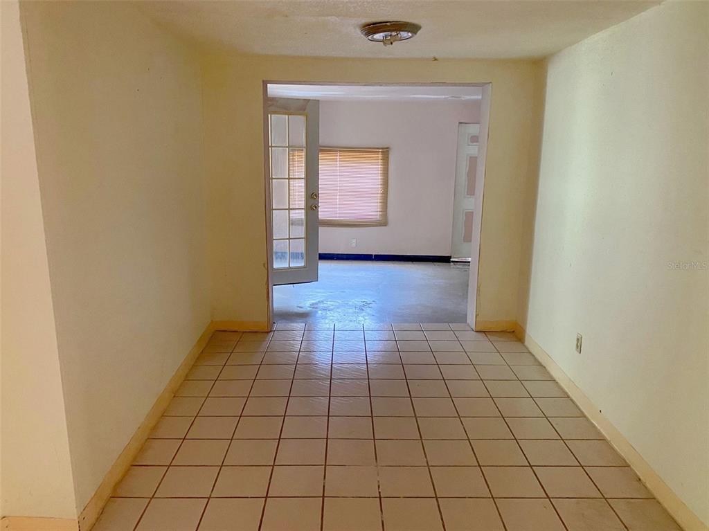 A tiled room leads through an open doorway into a secondary space with a window — 3716 E CLIFTON STREET, TAMPA, FL
