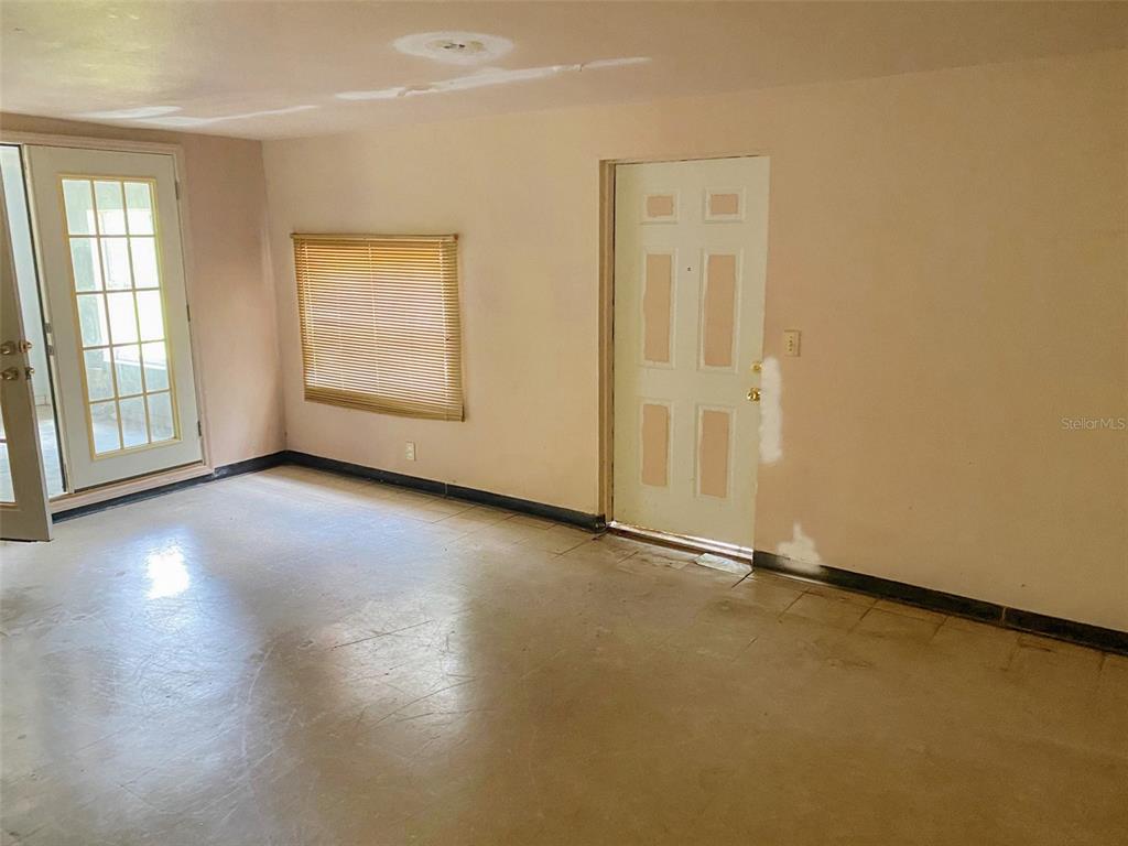An interior room features a glass-paned door, a window with blinds, and a white door — 3716 E CLIFTON STREET, TAMPA, FL