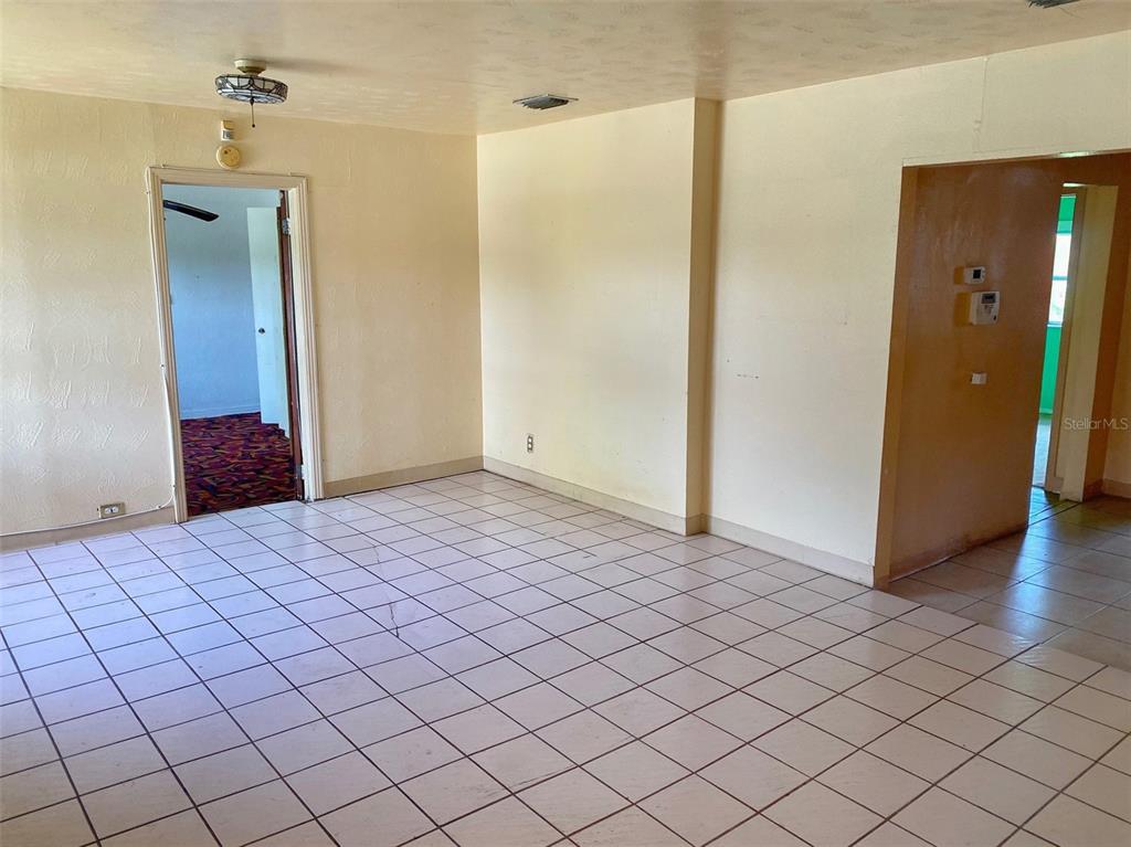 An interior view of a room with light-colored walls and white tiled flooring — 3716 E CLIFTON STREET, TAMPA, FL