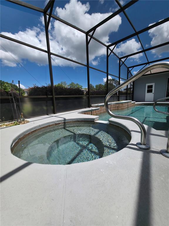 A screened-in patio features a circular hot tub and a swimming pool — 4724 SABLE RIDGE COURT, LEESBURG, FL