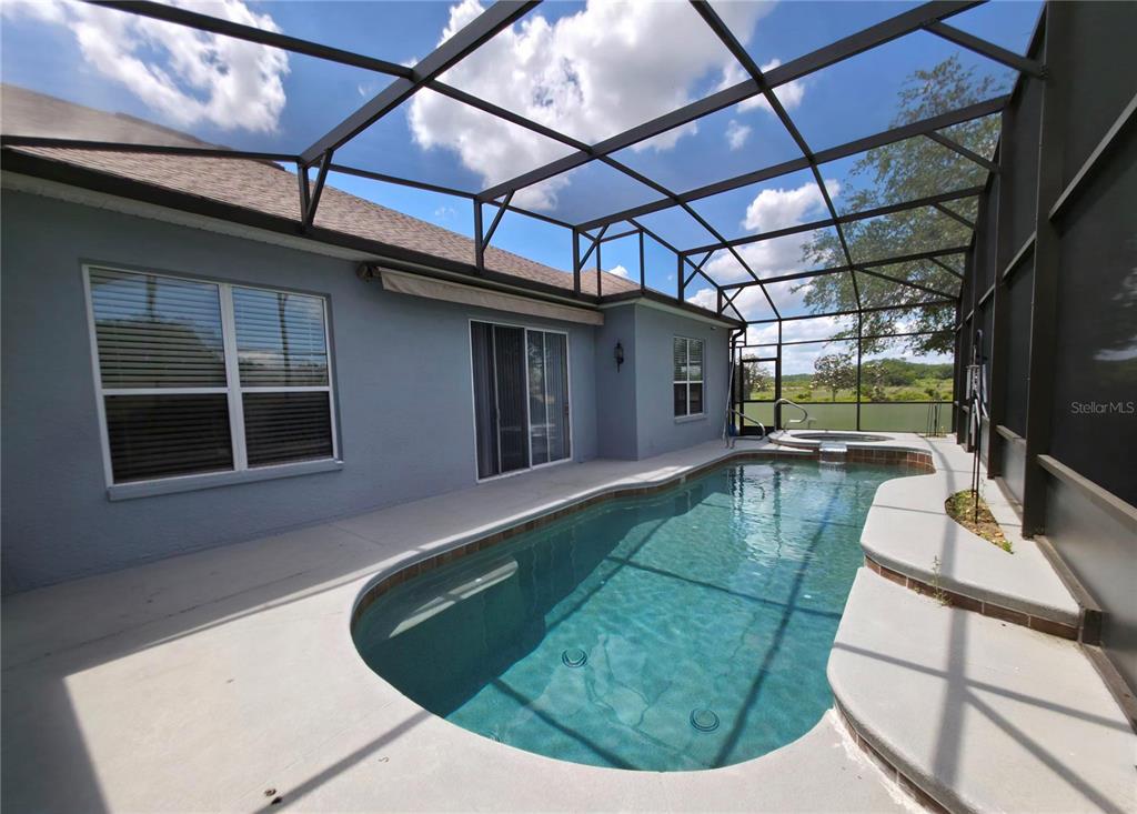 A screened-in patio features a swimming pool with an attached spa and concrete decking — 4724 SABLE RIDGE COURT, LEESBURG, FL