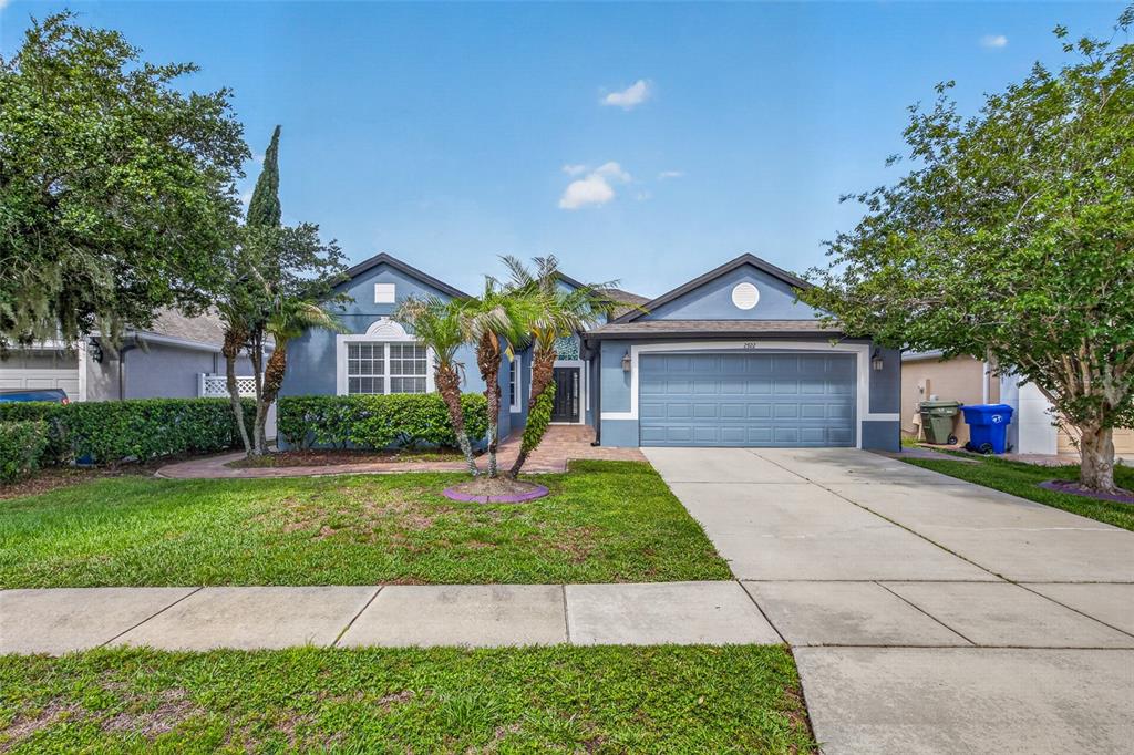 A blue single-story house with a two-car garage and a front lawn — 2922 WILLOW CREEK LANE, KISSIMMEE, FL