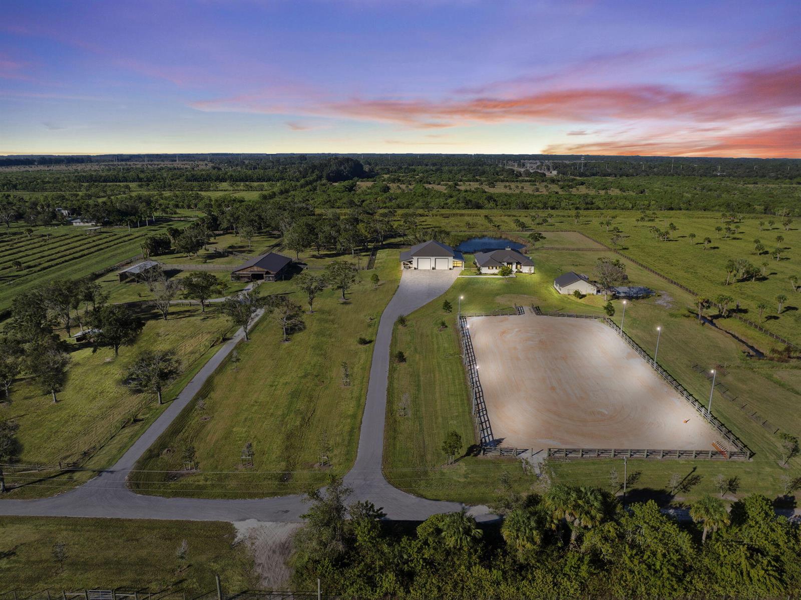 An aerial view of a rural property featuring a house, barn, and large riding arena — 4044 Johnston Road, Fort Pierce FL 34951, FORT PIERCE, FL