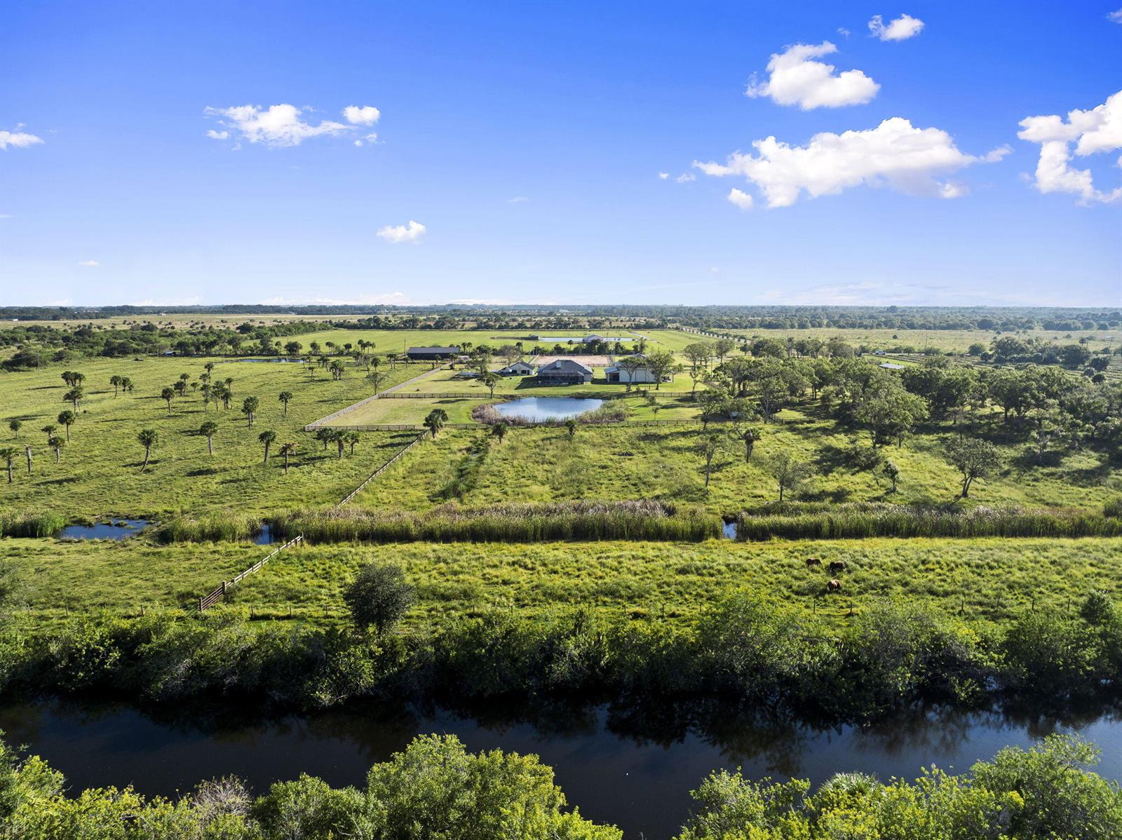 An aerial view shows a rural property with a house, pond, and fenced pastures — 4044 Johnston Road, Fort Pierce FL 34951, FORT PIERCE, FL