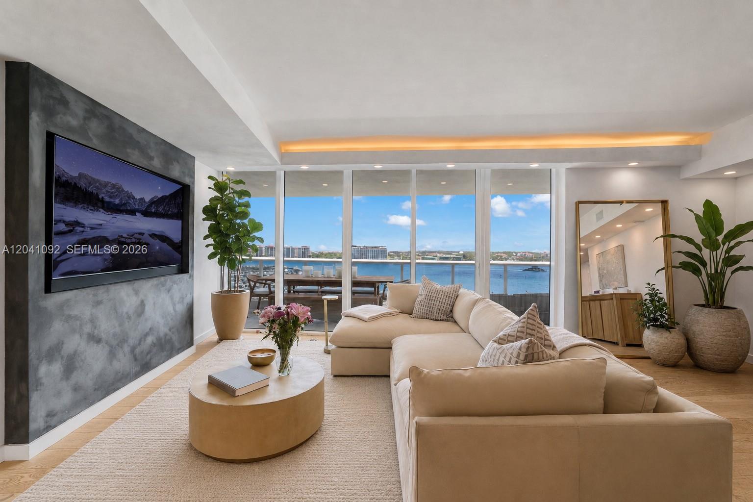 A living room features a large sectional sofa, a textured accent wall, and floor-to-ceiling windows — 400 Alton Rd # 1206, Miami Beach FL 33139, MIAMI BEACH, FL