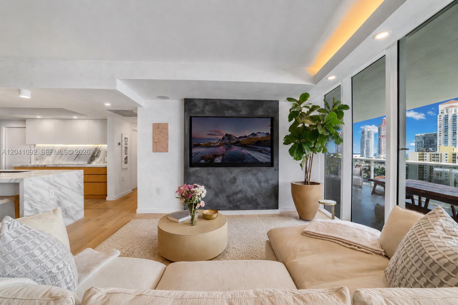 A modern living room features a dark textured accent wall with a mounted television — 400 Alton Rd # 1206, Miami Beach FL 33139, MIAMI BEACH, FL