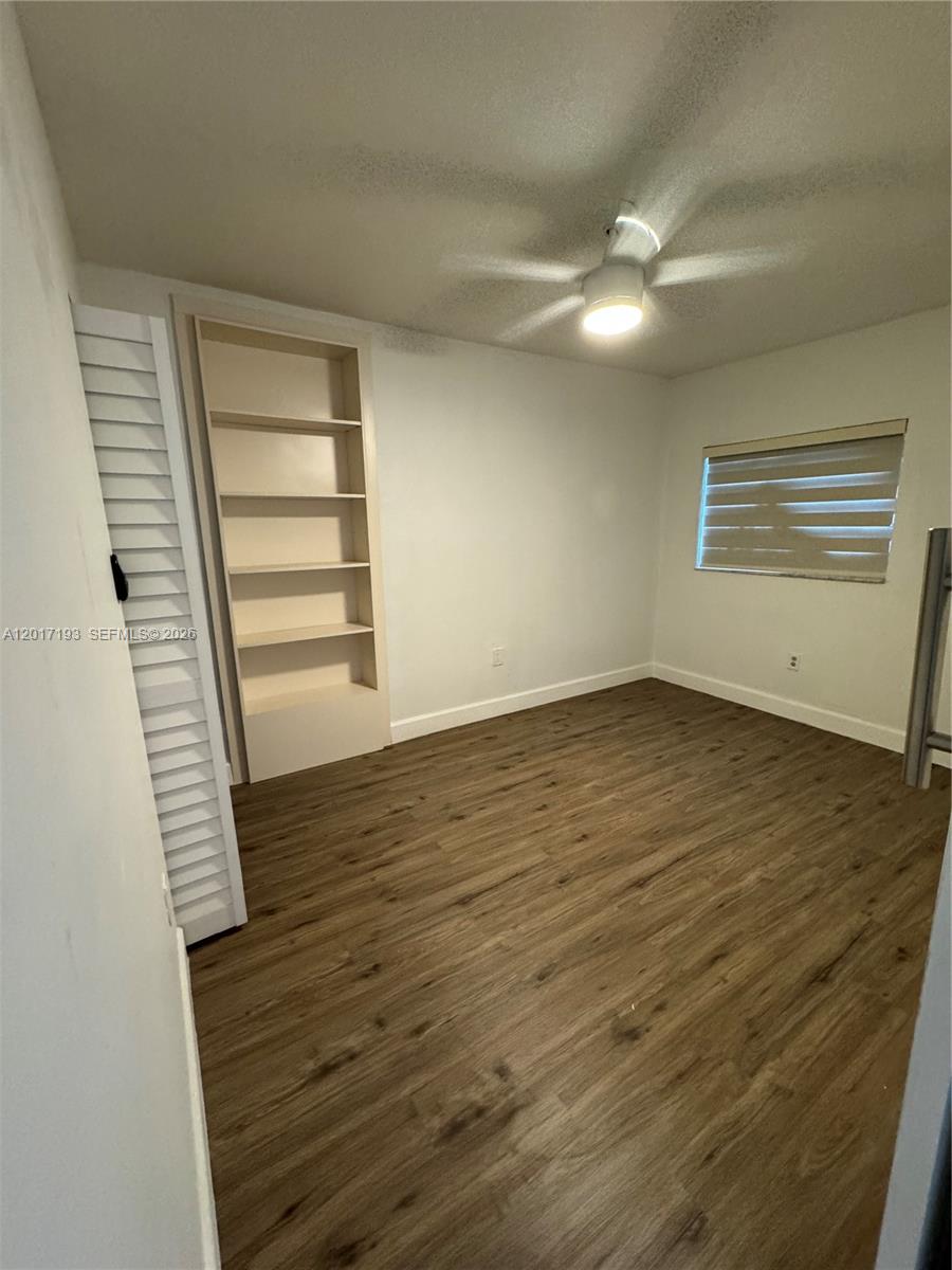 A bright room features light wood-look flooring, a ceiling fan, and a white barn door — 235 SW 64th Ave # 2B, Miami FL 33144, MIAMI, FL