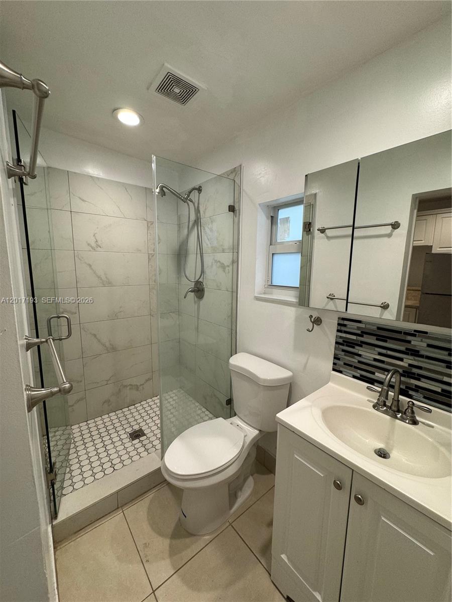A kitchen features white cabinets, stainless steel appliances, a tan countertop, and light tile flooring — 235 SW 64th Ave # 2B, Miami FL 33144, MIAMI, FL