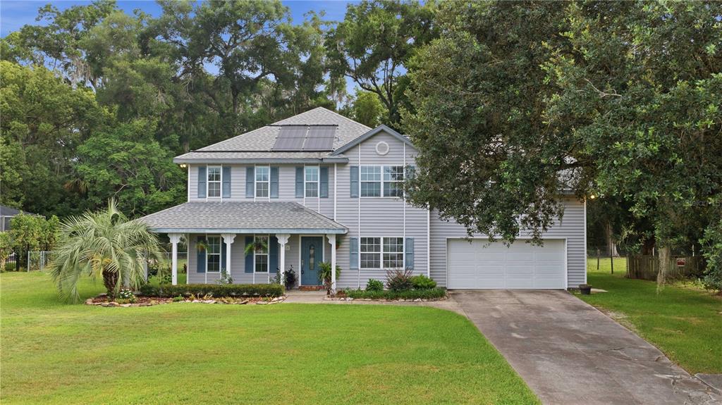 A two-story house with light gray siding, a front porch, and a two-car garage — 3015 SE 40TH STREET, OCALA, FL