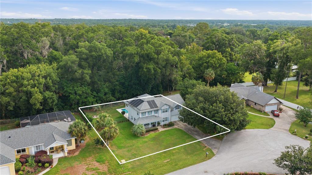 An aerial view shows a two-story house with solar panels and a backyard pool — 3015 SE 40TH STREET, OCALA, FL