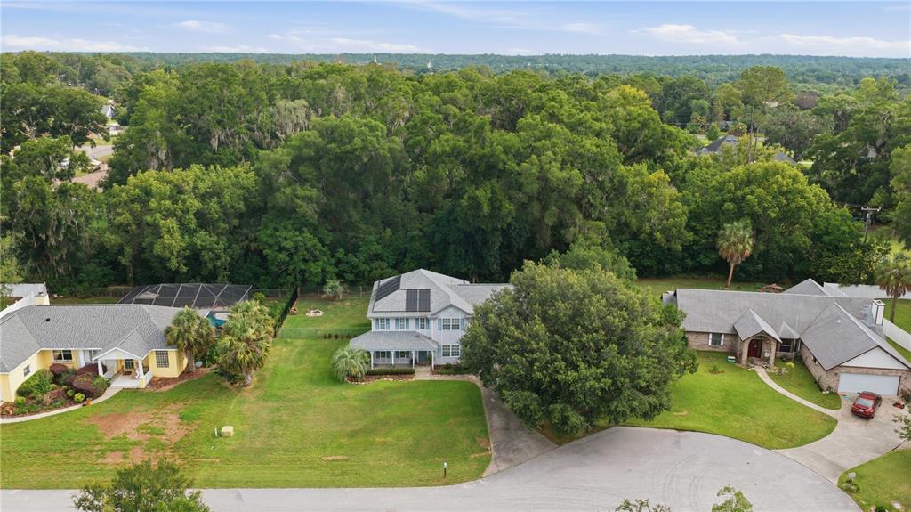 An aerial view shows three suburban houses with large lawns and surrounding trees — 3015 SE 40TH STREET, OCALA, FL