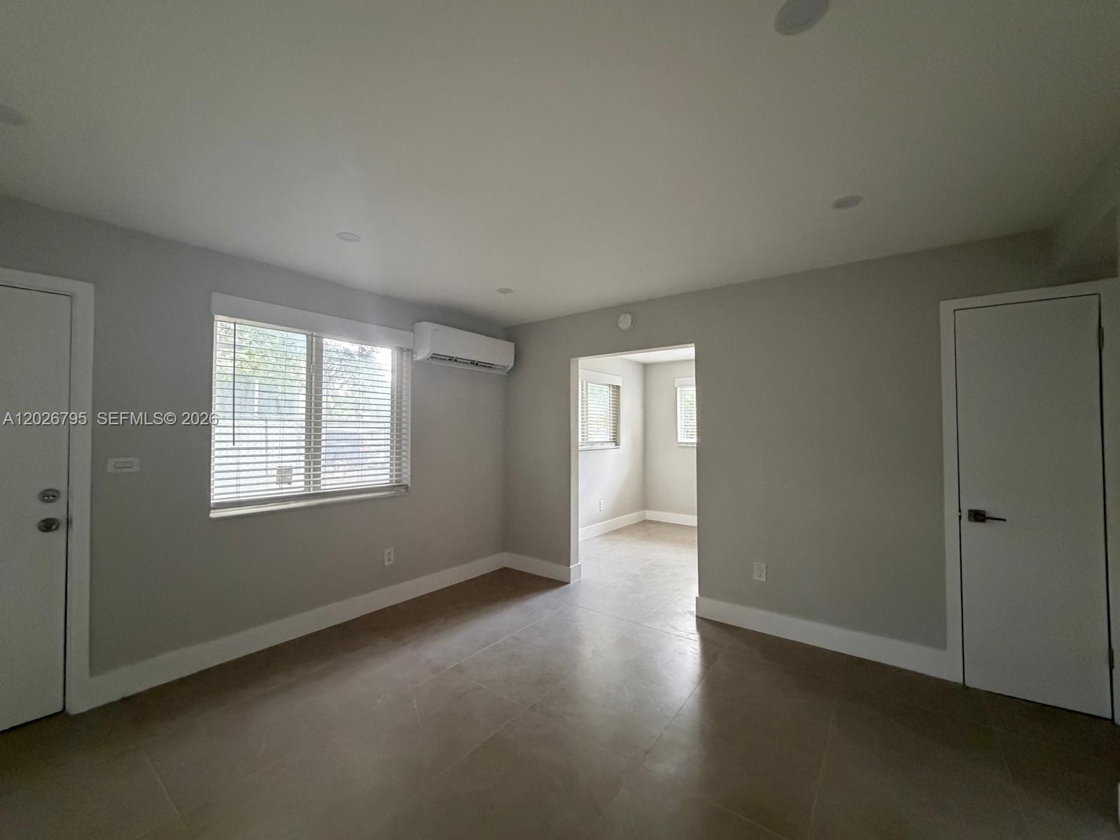 A room with light gray walls, tile flooring, a window, and a doorway to another room — 1844 NW 19th St # 1, Miami FL 33125, MIAMI, FL