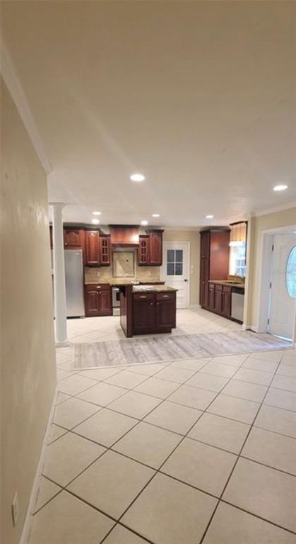 A kitchen with dark wood cabinets, a center island, and light-colored tile flooring — 3805 NW 50TH STREET, GAINESVILLE, FL