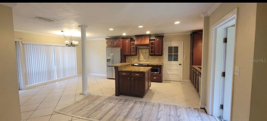 A kitchen with dark wood cabinets, granite countertops, a center island, and tile flooring — 3805 NW 50TH STREET, GAINESVILLE, FL