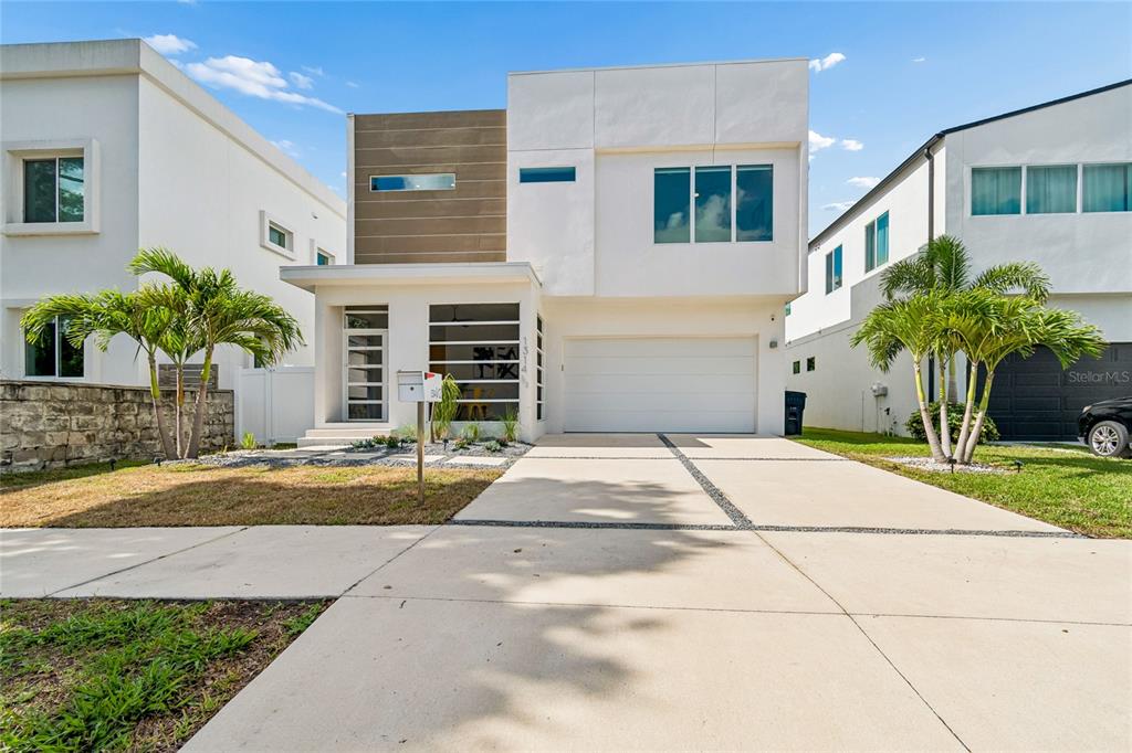 A modern two-story house with a white facade, wood-paneled accent, and a two-car garage — 1314 1/2 W. LEMON STREET, TAMPA, FL