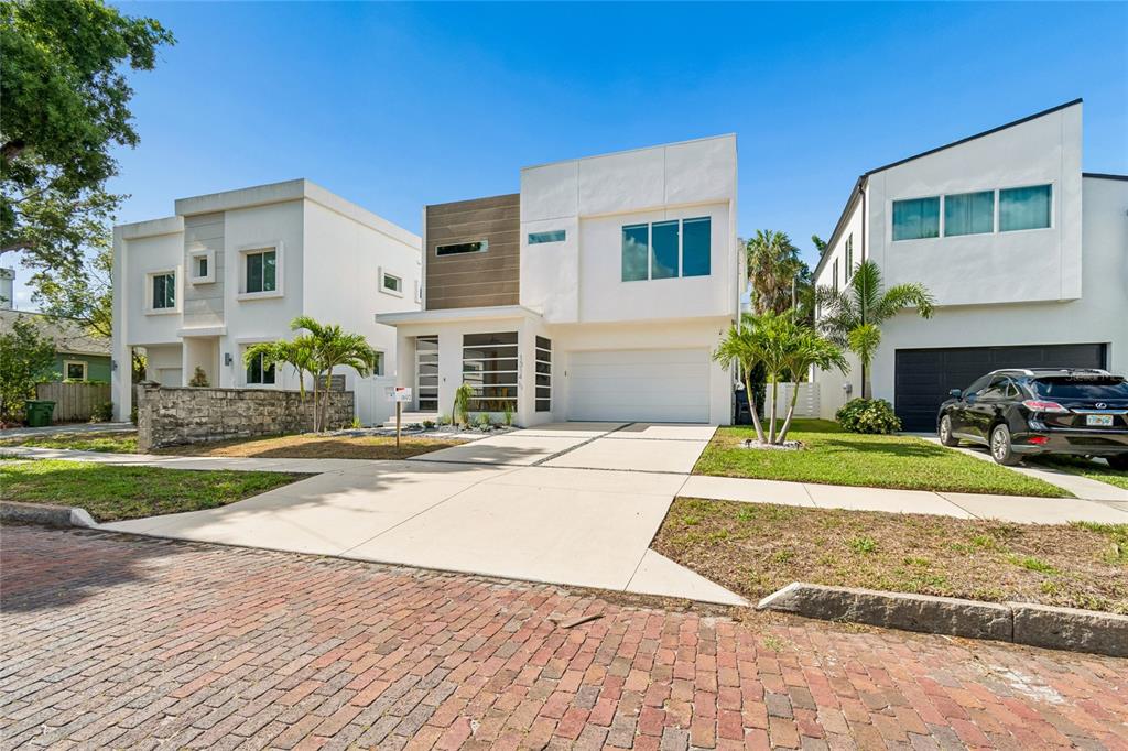 A modern two-story house with a white facade, wood accents, and a concrete driveway — 1314 1/2 W. LEMON STREET, TAMPA, FL