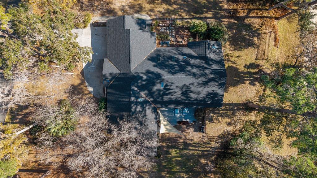 An aerial view shows a house with a dark shingled roof and a backyard patio — 4400 SW 20TH AVENUE, OCALA, FL