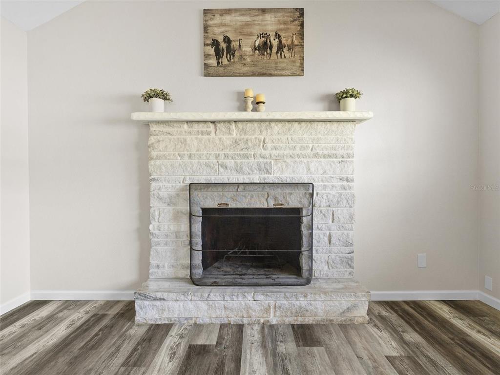 A stone fireplace with a mantel and a horse painting stands in a room — 4343 NW 80TH AVENUE UNIT 7, OCALA, FL