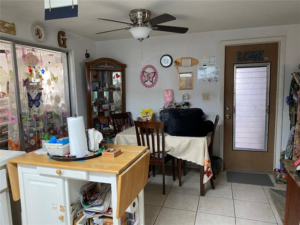 A kitchen and dining area features a wooden island, a dining table, and a glass door — 10018 CHERRY CREEK LANE, PORT RICHEY, FL