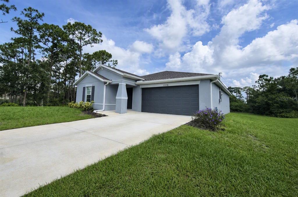 A single-story house with a gray exterior, a two-car garage, and a concrete driveway — 23234 ALASKA AVENUE, PORT CHARLOTTE, FL