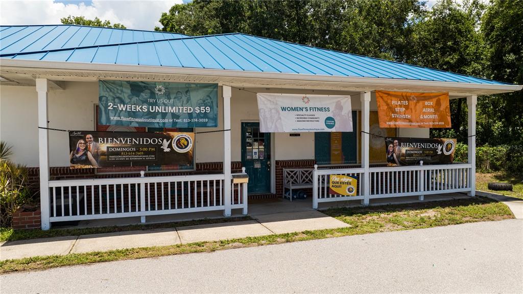 The exterior of a single-story building features a blue metal roof and a front porch — 11331 US 301 HWY, RIVERVIEW, FL