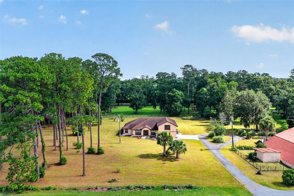An aerial view shows a single-story house surrounded by a large grassy yard and trees — 8650 SW 27TH AVENUE, OCALA, FL