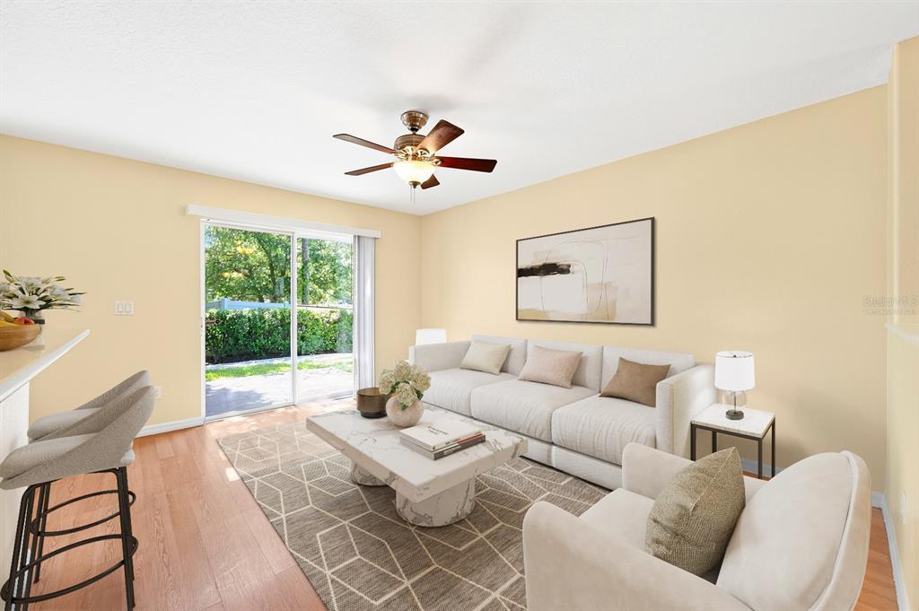 A living room features a white sofa, marble coffee table, area rug, and sliding glass doors — 12905 LEXINGTON SUMMIT STREET, ORLANDO, FL